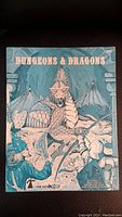 Front cover of the 1978 Dungeons & Dragons guide book showing a dragon and a knight in armor illustration with the title text.
