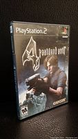 Front of the Resident Evil 4 PlayStation 2 game case showing main character with gun, ESRB M rating, Capcom logo.