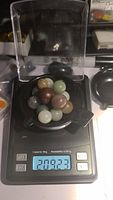 Photo of multiple natural polished agate spheres and gemstone spheres on a digital scale showing a weight of 209.23 carats.