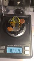 Weighing the collection of polished oval and round gemstones showing a total weight of 102.28 carats, matching seller's stated total weight of 102.27 ct.