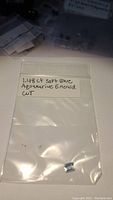 Photo of a small plastic bag with handwritten label describing the gemstone as 1.48ct soft blue aquamarine emerald cut, untreated.