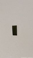 Top view of rectangular baguette cut green tourmaline showing deep forest green color and clarity.