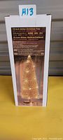 Photo of the product box showing the gold glitter Christmas tree with LED lights in use. Box text confirms size as 10 inches with battery powered LED lights.