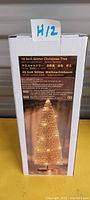 Photo of the product box showing the 10 inch glitter Christmas tree with LED lights and product details.