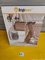 Front of box showing Brightown branding and image of the heater with a dog, highlighting overheat safety shutoff and quiet operation.