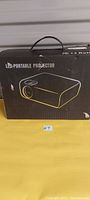 Box of LED Portable Projector with handle showing the product outline and labeling.