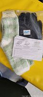 Two pairs of Aeropostale fuzzy crew socks in green-white colors and one pair of black wired heated gloves shown with instructions.