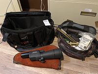 Overview of spotting scope, suede sleeve, black nylon bag, and camouflage reloading pouch with contents