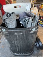 Black heavy duty rolling crate filled with multiple folded camping chairs and a carrying bag.