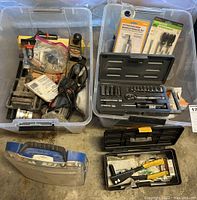 Overview of multiple plastic containers with socket sets, hand tools, and screwdrivers along with a handheld router.