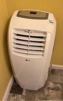Front view of LG portable air conditioner showing air vents, control panel on top, and LG logo on front.