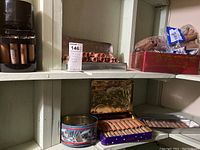 Shelf overview showing black plastic coin counting and rolling machine at left and tins of paper coin rolls at right.