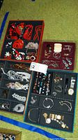Four-section red tray containing red bead necklaces, wood disc pendant and red/black costume pieces