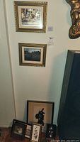 Two framed foil art prints hung on the wall above other framed art pieces and beside a metal wall sculpture