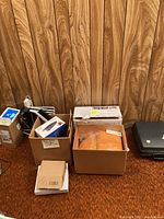 Overall view of assorted items including boxes of Shamwow towels, automotive tools, and heater box.