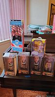 Lot of 4 Jeff Dunham talking headknockers including the character Walter, 1 Rugrats doll, and 1 Ronald Reagan talking action figure displayed in original packaging on a table.