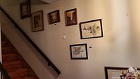 Six pieces of wall art arranged on a stairway wall, showing size, framing, and placement.