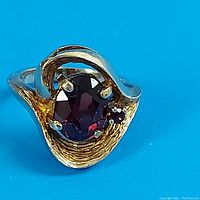 Front view of ring showing garnet and gold swirl design