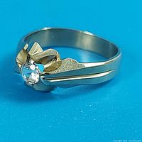 Front/side angle view of ring and diamond setting on blue background