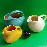 Group view of three pitchers (yellow, white, turquoise) with small orb size reference