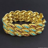 Front view of bracelet showing textured links with turquoise beads and red rhinestones