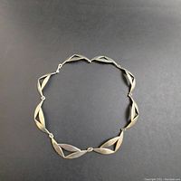 Top view of necklace laid flat showing geometric link pattern.