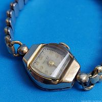 Close-up of Rolex Tudor ladies watch face showing missing part of the hour hand and gold arabic numerals on dial.