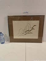 Single framed “Spring Flight” print with brown mat and metal frame, shown with scale bottle