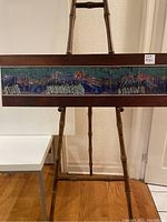 Full frontal view of the mid-century tile art panel mounted in a wooden frame on an easel.