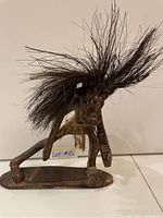 Front view of vintage African wooden carving showing facial features, hair, and base