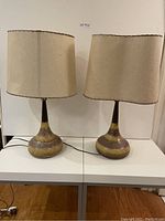 Front view of both lamps side by side on white table, showing full height and shape