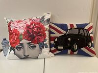 Two cushions side by side: floral face print and needlepoint Union Jack with black taxi