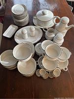 Full set of Stonehenge Midwinter dishes displayed on a table showing variety of plates, bowls, cups, serving pieces, and salt and pepper shakers.