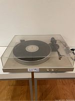 Front view of T35 turntable with clear dust cover and vinyl record on platter