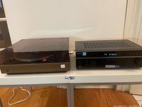 Dual 510 turntable with dust cover and Sony STR-DE197 receiver side by side on table.