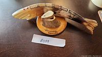 Fish-shaped bone cribbage board showing full length and mounted base with Vancouver Canada marking.