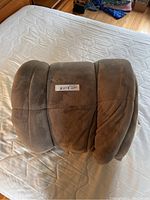 Rolled brown king size blanket showing soft plush exterior fabric with sewn seams, laid on a mattress.