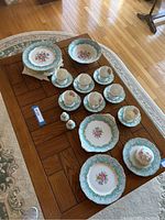 Full lot layout on dining table showing bowls, cups, saucers, plates, covered butter dish and salt & pepper shakers