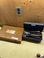 Wooden case and plastic case with woodworking tools on a workbench.
