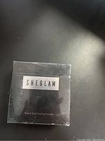 Front view of sealed black packaging with SHEGLAM branding and product name