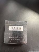 Front view of the box showing brand SHEGLAM and product name Baked Glow Setting Powder.