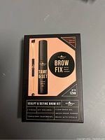 Front of the Browfix Sculpt & Define Brow Kit box showing the three pieces included: clear brow gel, waterproof pomade, and brush with spoolie.