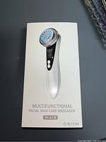 Photo of the unopened retail boxed facial skin care massager model W-618 showing the device image and model name on the box.