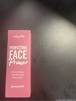 Pink box of Amor Us Perfecting Face Primer Translucent with key features like oil-free, poreless, skin-perfecting, shine control shown