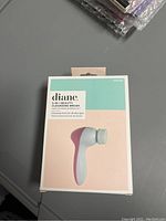 Front view of unopened Diane 5-in-1 Beauty Cleansing Brush retail packaging showing the product image and brand name