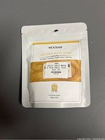 Photo of sealed pouch of Mooyam 24K Gold Jelly Mask showing front packaging with product details and price sticker