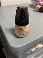 A photo showing a single unopened bottle of Amuse Cosmetics Full Coverage Liquid Foundation with satin finish in a beige shade.