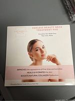 Front of the box showing product name, brand Dreambox Labs, image of woman, benefits such as improving fine lines and wrinkles, hydrating skin, boosting collagen production, and reusable medical grade silicone neck pad note.
