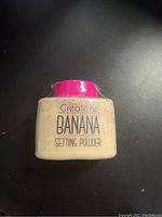 Photo showing the front of the unopened Beauty Creations Banana Setting Powder container with pink lid.