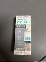 Photo of unopened box of Bye Bye Blemish Volcanic Ash Drying Lotion in white and blue packaging.